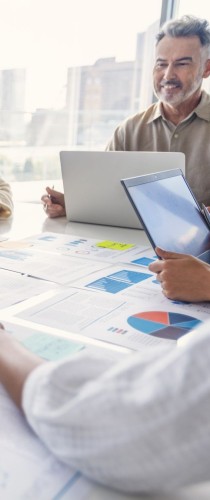 Team reviewing data charts and graphs during collaborative meeting with laptop.