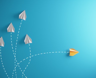 Paper airplanes on blue background showing different paths