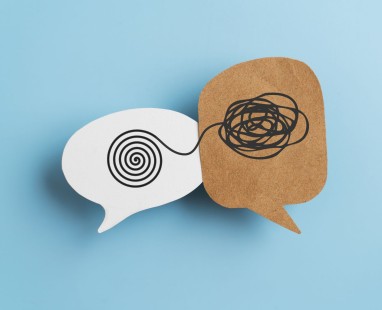Contrasting speech bubbles against blue background—white bubble with ordered spiral connecting to brown bubble with scribbled circles