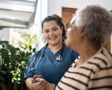 Healthcare worker speaking with elderly patient