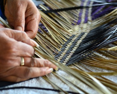 Hands weaving flax
