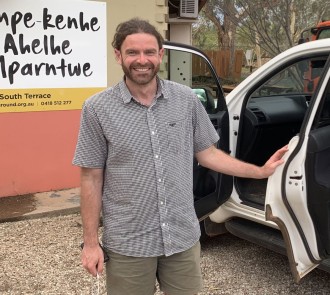 Team member arriving at Ape Kenhe Ahelhe learning center in Central Australia, ready for community engagement work.