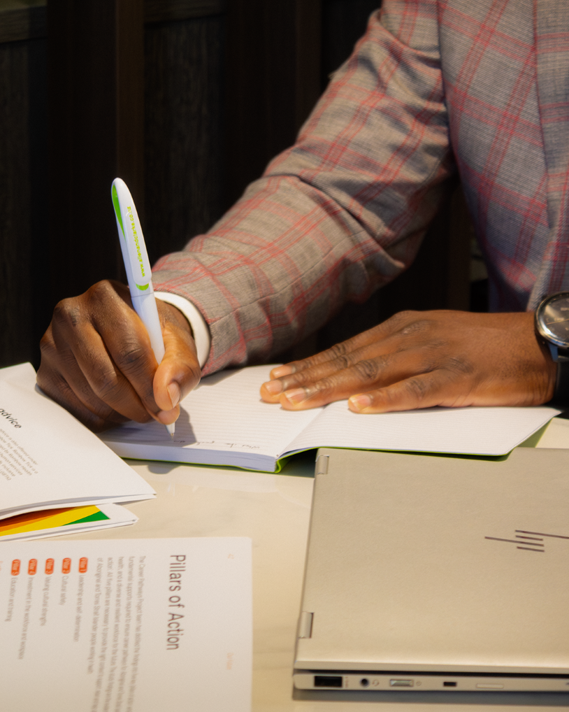 Close-up of hand writing notes on document, capturing key information during consultation process.