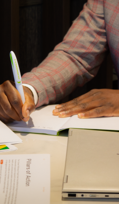 Close-up of hand writing notes on document, capturing key information during consultation process.