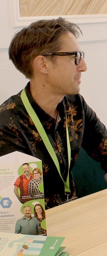 Participant with event credentials at conference table with informational materials.
