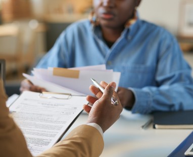  Person passing documents across table in professional setting