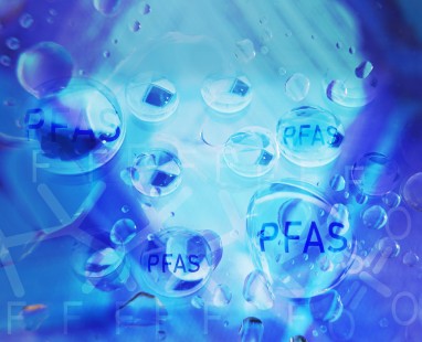 Blue water droplets labeled "PFAS," visualizing persistent chemicals in our water systems and their environmental impact.